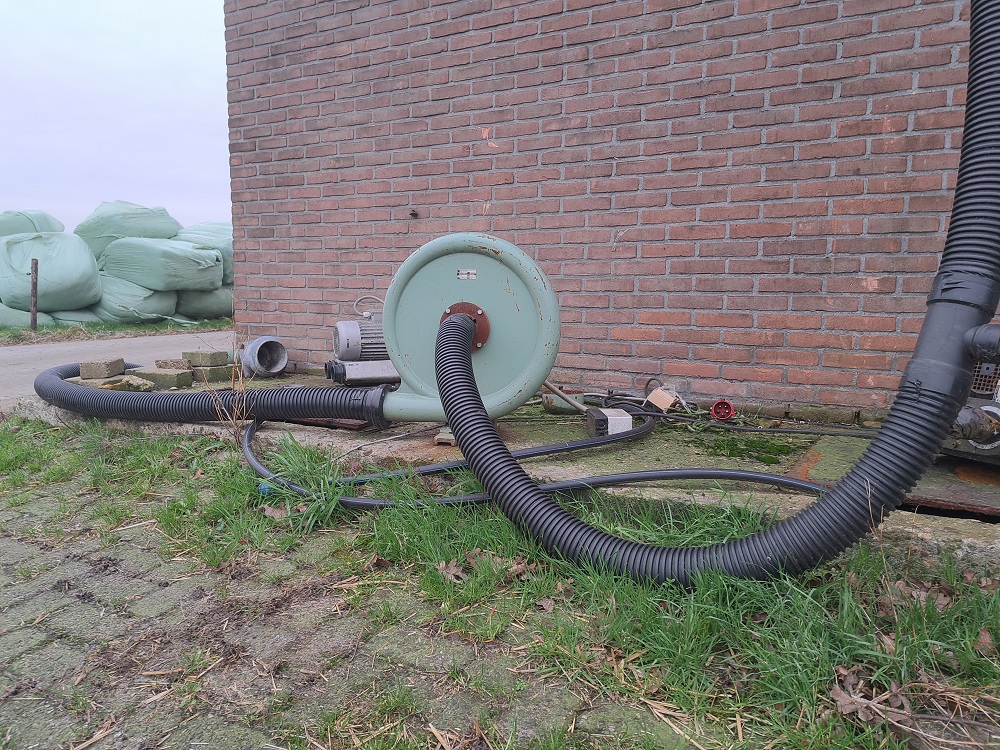 De luchtpomp zuigt lucht uit de mestput en brengt het via drains in de bodem van het grasland. 